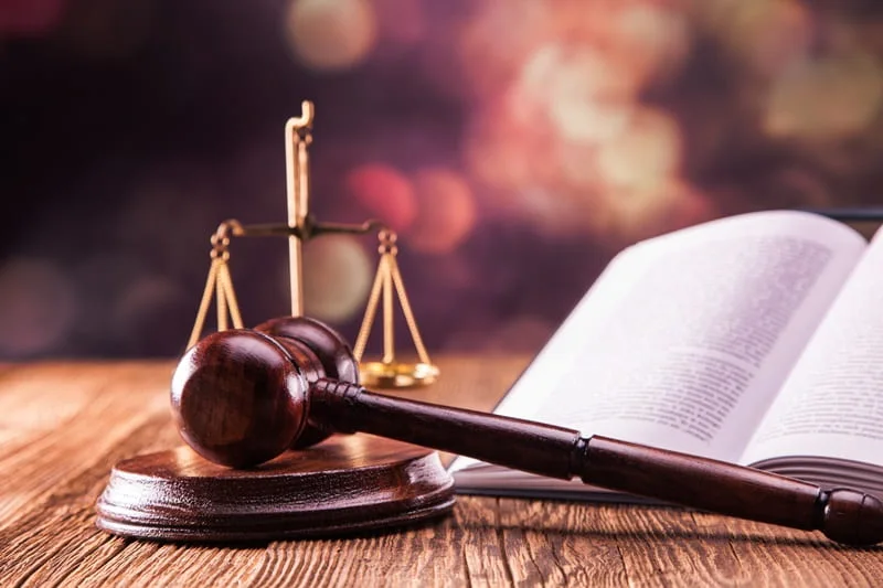 A gavel and scales beside an open law book